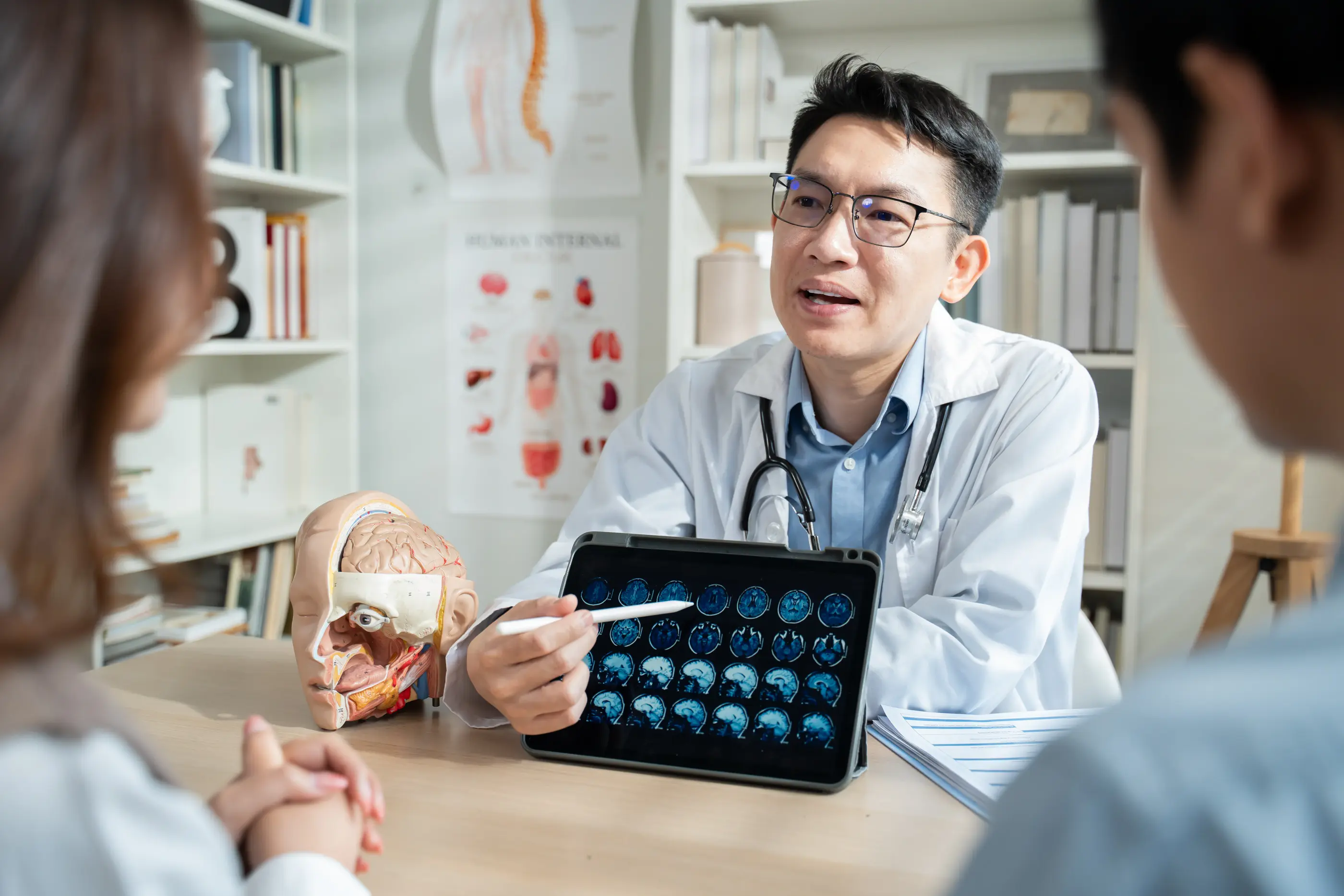 A neurologist explaining brain MRI results to a couple.