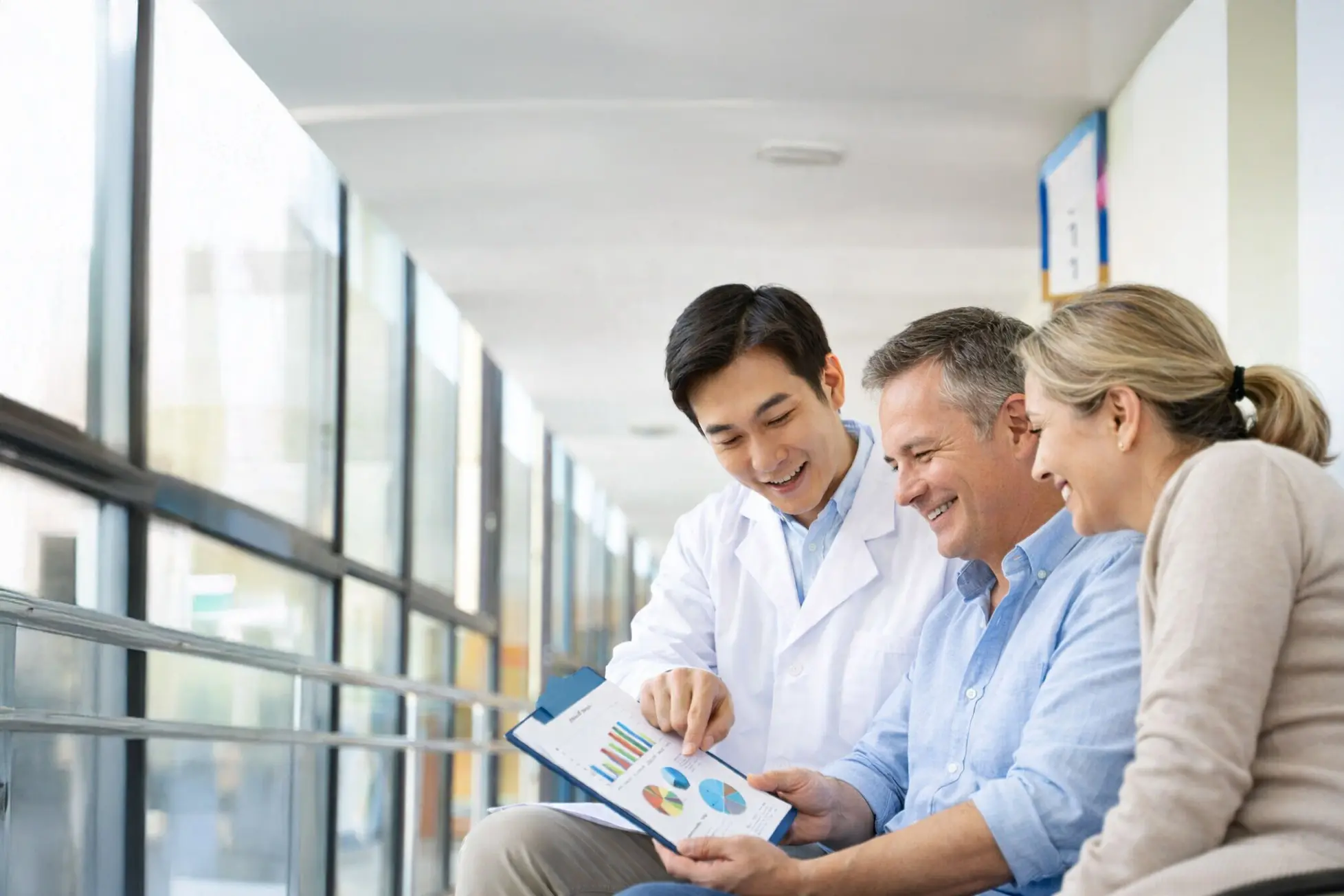 A doctor reviewing results with a smiling couple after their assessment.