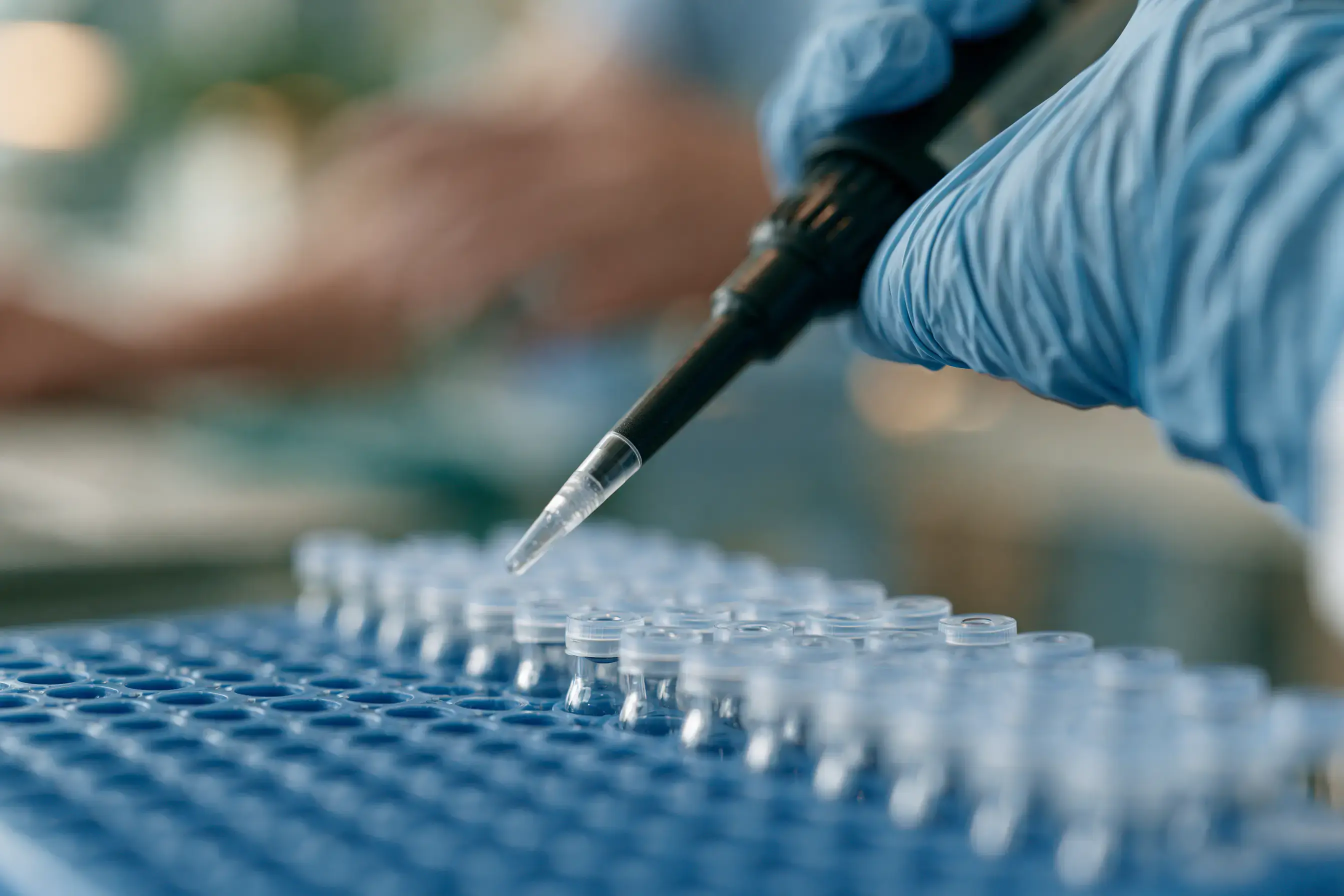 Samples being pipetted into vials for laboratory analysis.