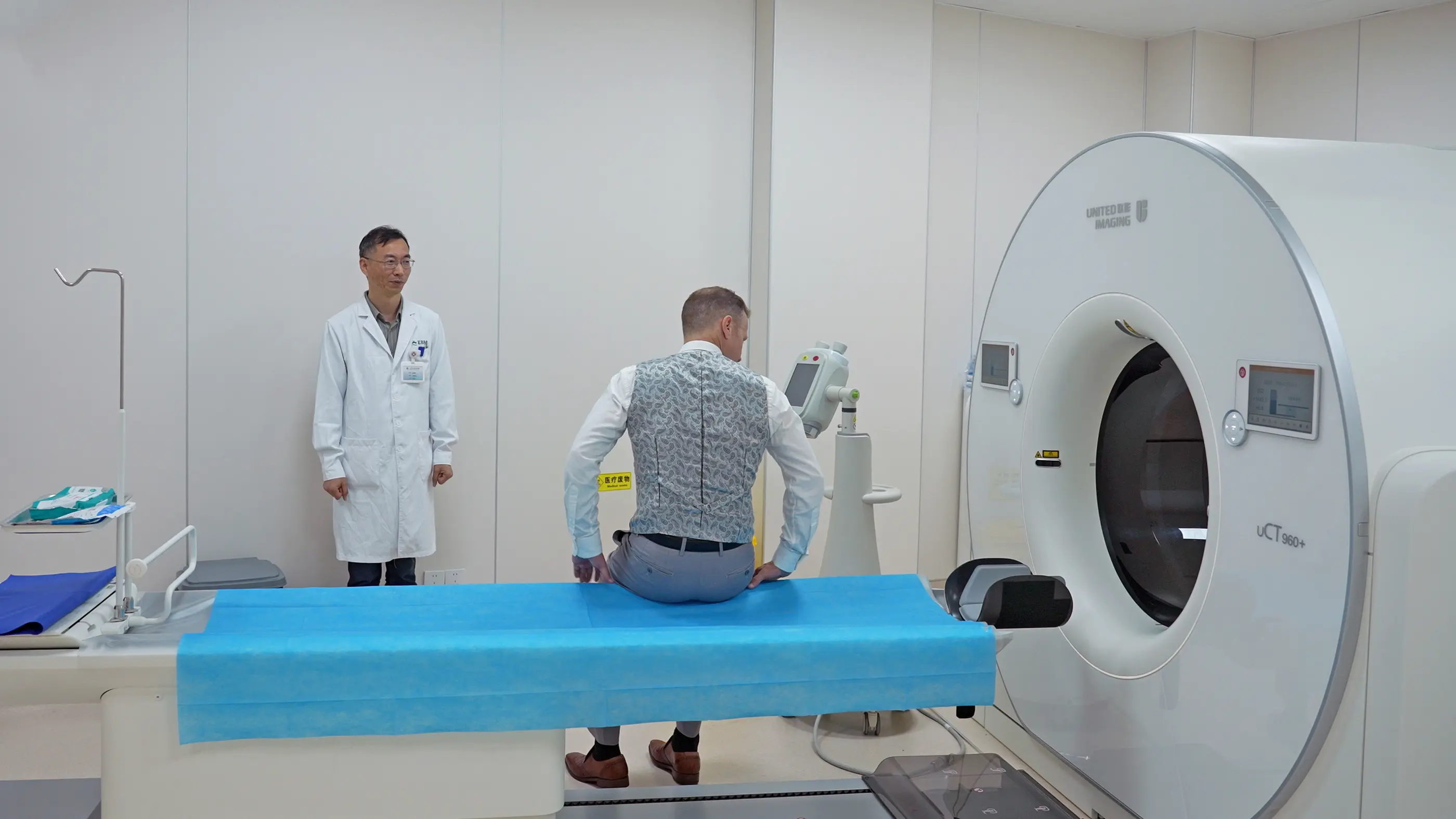 A guest with a doctor beside the scanner at Shanghai International Medical Center.