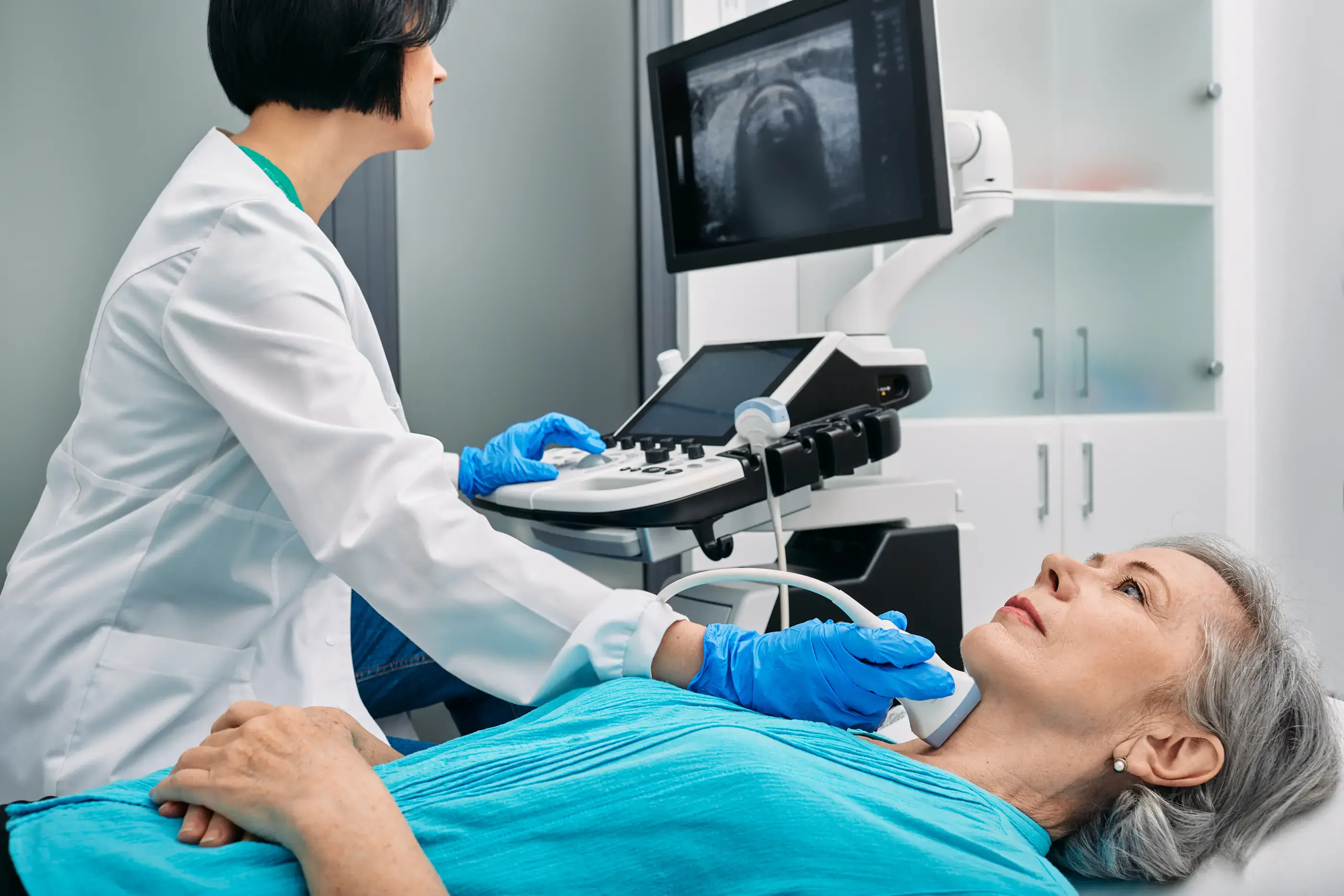 A clinician performing a thyroid ultrasound.